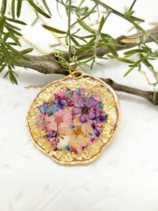 Women's real flowers medallion necklace in resin. Oval pendant in brass and gold steel chain. Dried pressed flowers. Personalized gift