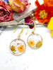Orecchini cerchi piccoli pendenti acciaio oro fiori veri Margherita in resina opale fiori arancio. Gioielli fiori veri essiccati pressati.