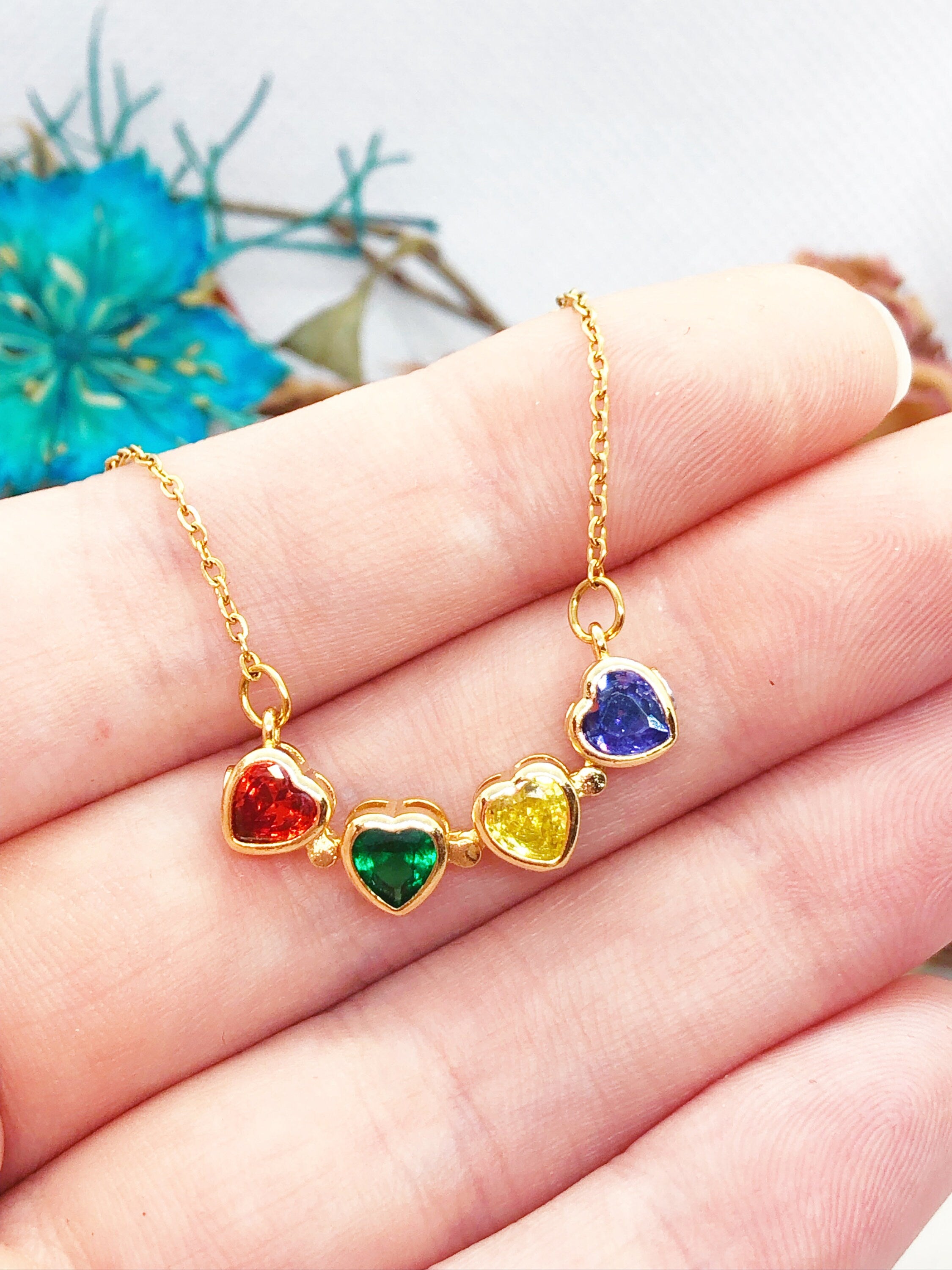 Collana con gemme cuore arcobaleno colorate. Il gioiello magnetico si trasforma in quadrifoglio. Collana multicolore acciaio oro anallergico